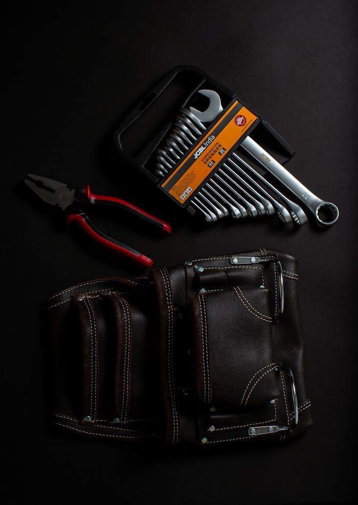 hand-tool-on-black-leather-bag-3784234 Premium hand tools and leather tool belt arranged on a dark surface. Ideal for projects.