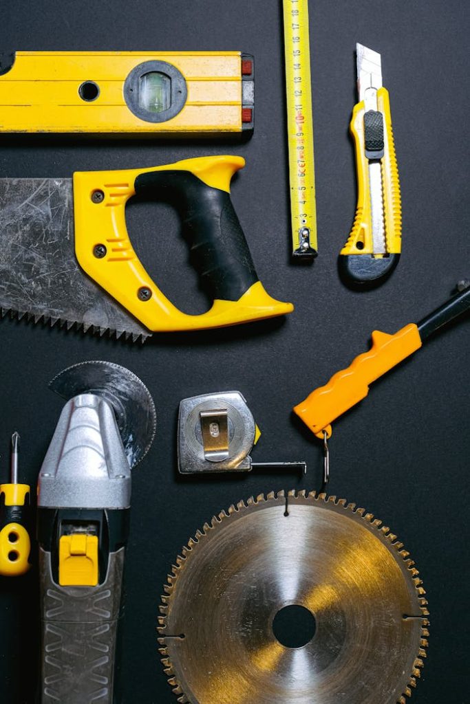 red-and-yellow-hand-tools-on-the-table-4312860 A collection of yellow and black construction tools arranged on a dark flat surface, ideal for DIY projects.